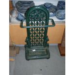 A green vintage cast iron umbrella stick stand.