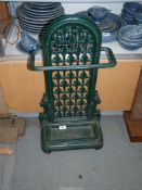 A green vintage cast iron umbrella stick stand.