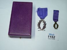 A boxed French Palmes Academiques medal.