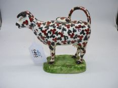 A circa 1870 Glamorgan pottery cow creamer decorated with red oxide and black trefoils,