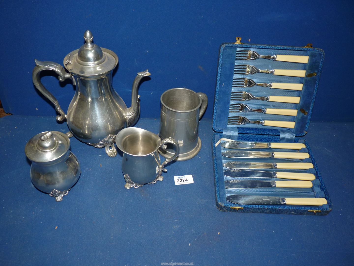 A box containing pewter coffee set with acorn finials,