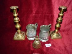 A pair of brass candlesticks with pushers, bell and two pewter tankards.