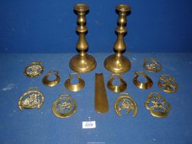 A small quantity of brass including horse brasses, pair of candlesticks and a shoe horn.