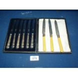 A cased set of silver handled butter knives and three silver collared dessert knives,