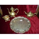 A brass coffee pot, tray, teapot and jug.