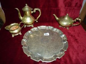 A brass coffee pot, tray, teapot and jug.