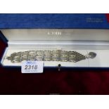 A Silver seven bar-gate Bracelet with silver locket, 7" long, maker H&M, in Crouch Jewellers box.