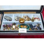 A jewellery box containing brooches, clip on earrings and pierced earrings.