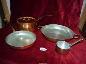 Four pieces of copper including saucepans and skillet.