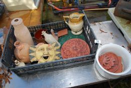 A quantity of terracotta plaques of sun faces and stoneware jars, etc.