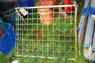 A wall mounted galvanised hay rack.