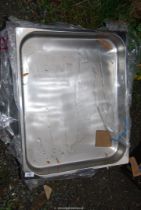 A quantity of stainless steel catering trays.
