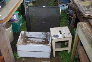 A large spark guard, wooden stool, and an old wooden crate.