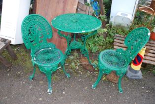 A circular cast iron/aluminum table and two chairs -27" wide x 28" high.