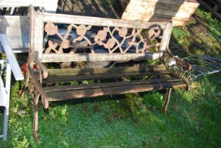 A garden bench with cast iron ends and iron floral feature back,