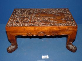 An Oriental carved wooden footstool with bamboo leaves, 15 1/4" wide x 9 3/4" deep x 7" high.