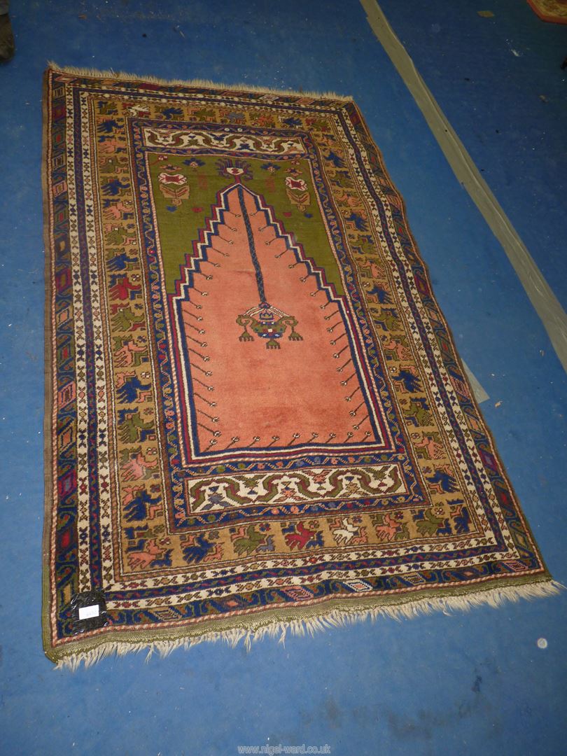 A bordered, patterned and fringed Rug in navy, green and terracotta colours, 72'' x 46''.