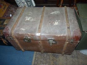 A bentwood bound trunk with leather corners, remains of luggage labels attached,