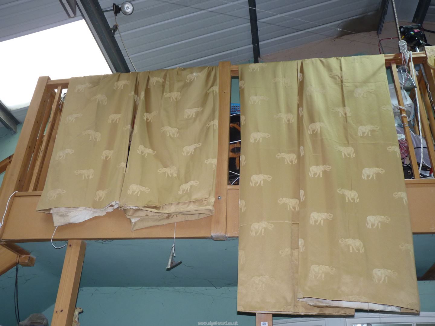 A pair of curtains in gold coloured fabric with Elephant design,