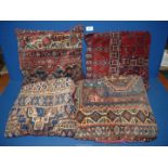 Four old carpet cushions in red and blue geometric pattern and red backs.
