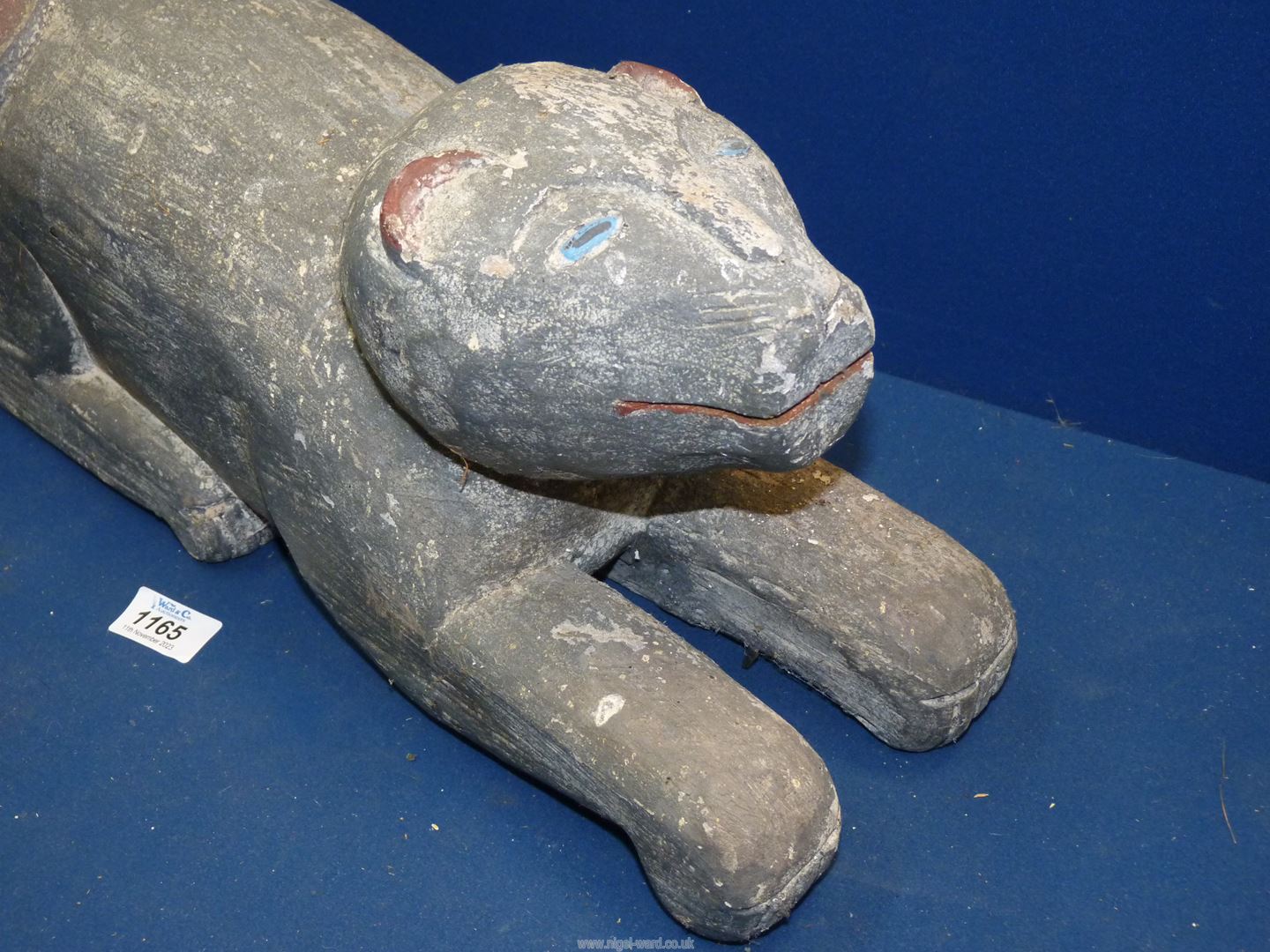 A heavy carved wooden figure of a stylized feline with painted details to the eyes, ears and tail, - Image 2 of 3