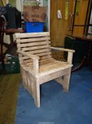 A rustic bleached hardwood open armed elbow chair with slated seat and back.