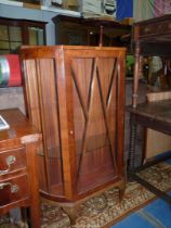 A Walnut finished china display Cabinet standing on brief cabriole legs,