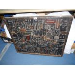 A large framed collage of printers blocks, 33'' x 27'', some loose.
