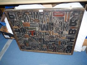 A large framed collage of printers blocks, 33'' x 27'', some loose.