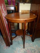 A circular Mahogany occasional table standing on shaped legs united by a lower shelf,