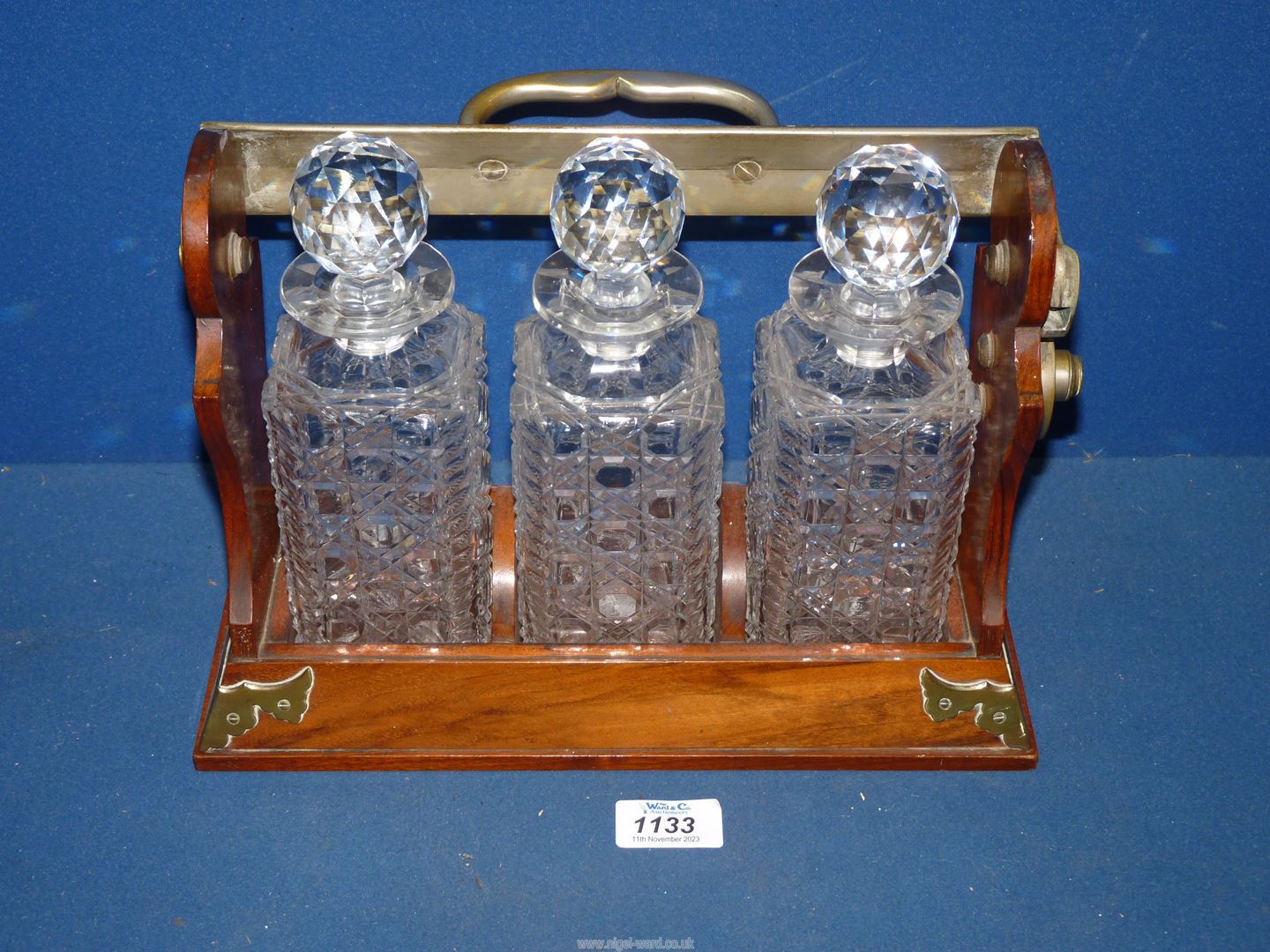 A Betjemann's wood and brass Tantalas with three cut glass decanters, makers Lloyd Payne Amie, - Image 3 of 3