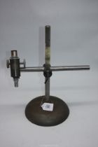 A "C. Baker, London" Microscope mounted on a heavily weighed adjustable industrial stand.
