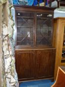 A circa 1900 Mahogany Bookcase on Cupboard having a pair of thirteen pane geometrically glazed