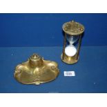 An Art Nouveau brass inkwell with holly decoration and bow, china inkwell present,