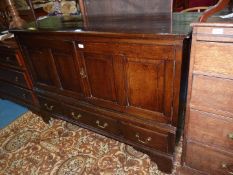 A four panelled dark Oak Mule Chest design Cupboard having a pair of double raised and fielded