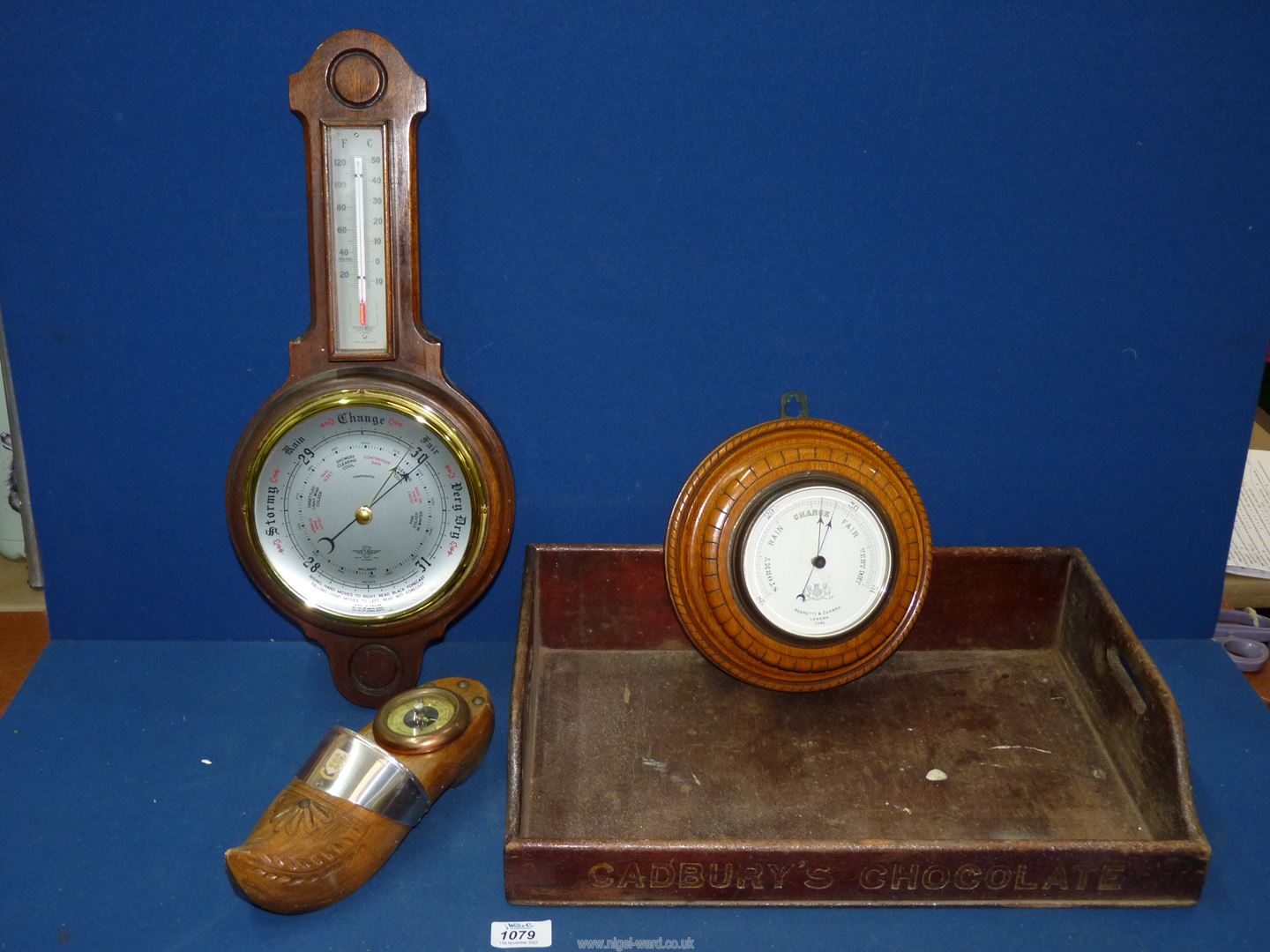 A 'Negretti & Zambra' barometer London on a carved oak base, wall hanging,