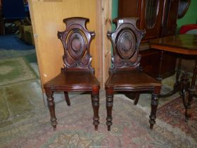 A good pair of circa 1900 Mahogany solid seated Hall Chairs having shaped seats and back rests with
