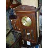 A Wall Clock in darkwood case and glass panelled door,