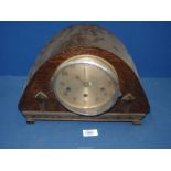 A dark wood domed Mantle clock with two diamond shapes to front and in a floral design to rim with