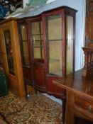 A circa 1900/1910 display cabinet having an inlaid decorated bowed central section cupboard with *