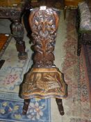 An arts and crafts carved Oak Spinning Chair, the back rest decorated with a branching plant,