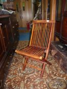A folding slatted seated and backed steamer style chair.