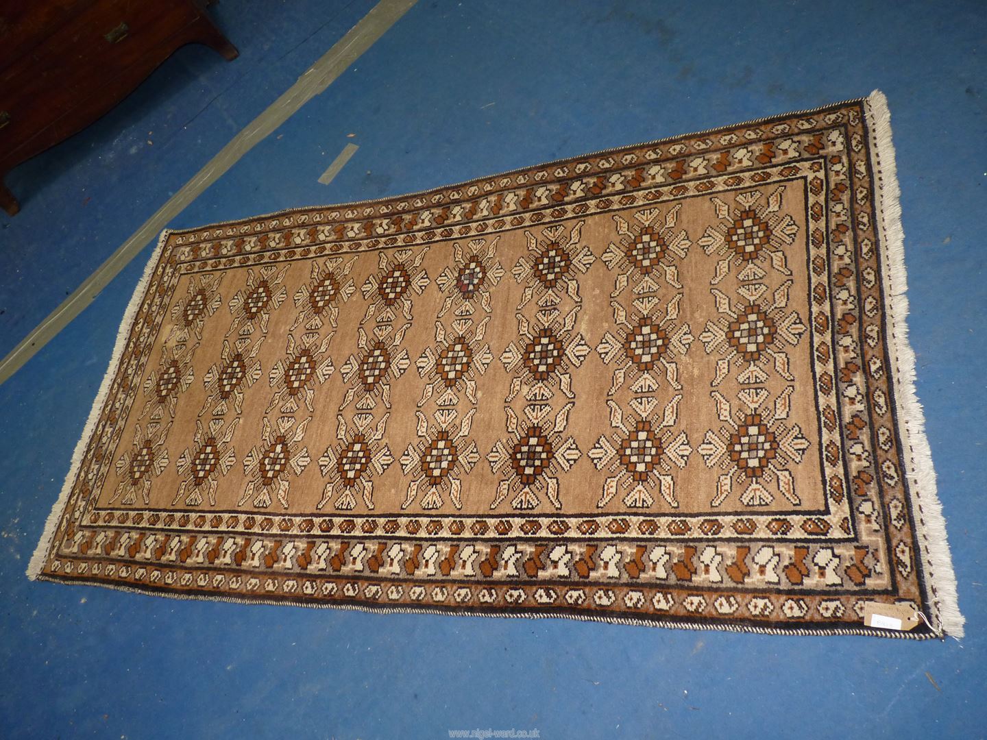 A handmade Balouch rug in browns and creams, 6' 4" x 3' 4".