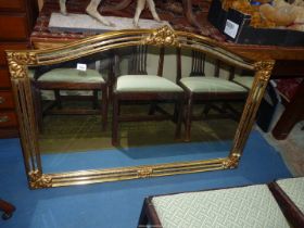 An arched top Overmantel Mirror having unusual narrow mirrored strips to the gilded finished frame,