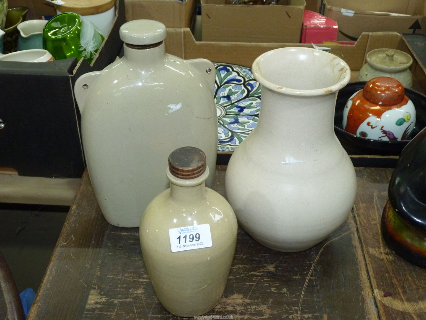 Three stoneware items; hot water bottle, vase and small bottle with lid.