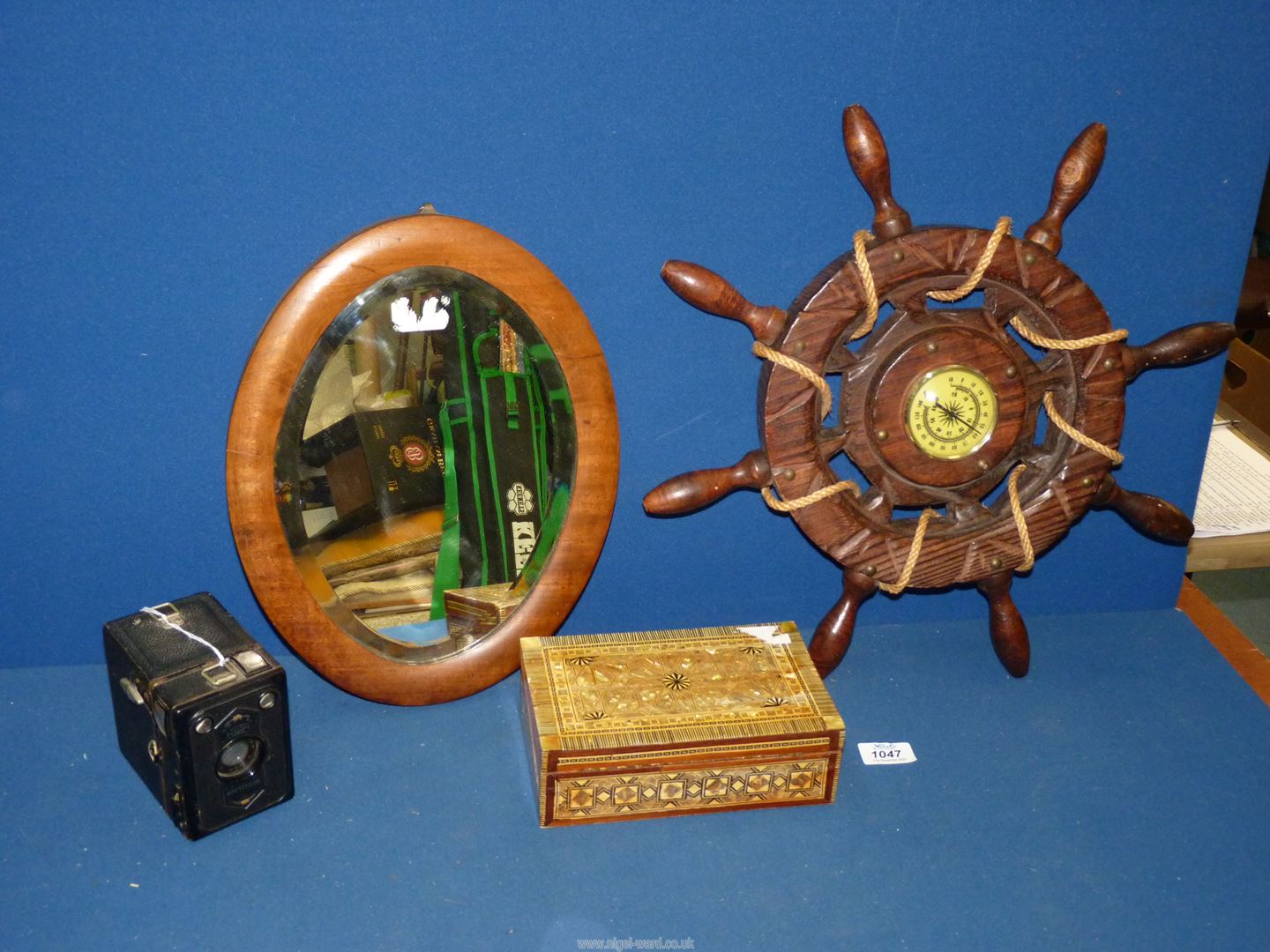 An early 19th century small oval bevelled wall mirror with satinwood frame, 14" long,