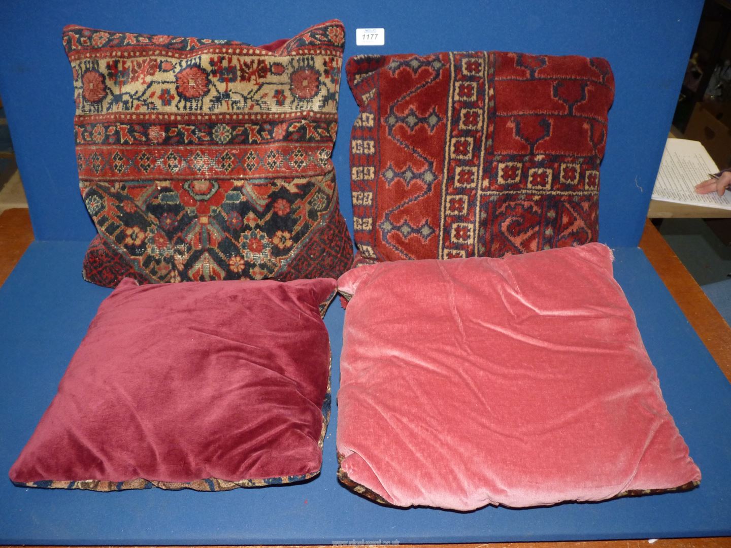 Four old carpet cushions in red and blue geometric pattern and red backs. - Image 2 of 2