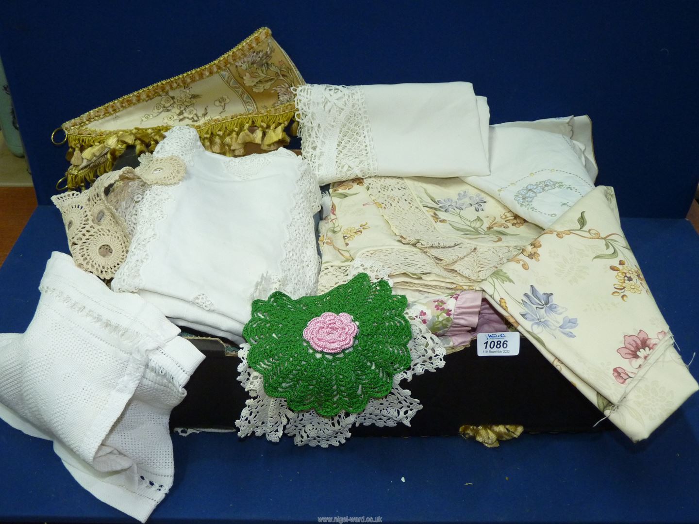 A box of crochet mats, tablecloths, embroidered tablecloths, etc.