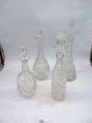 Four tall decanters all having stoppers.