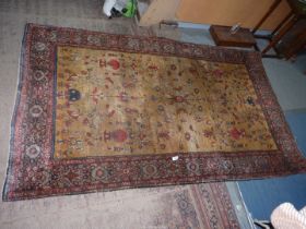 A bordered and patterned Eastern Rug with central panel decorated with a vase of flowers in reds,